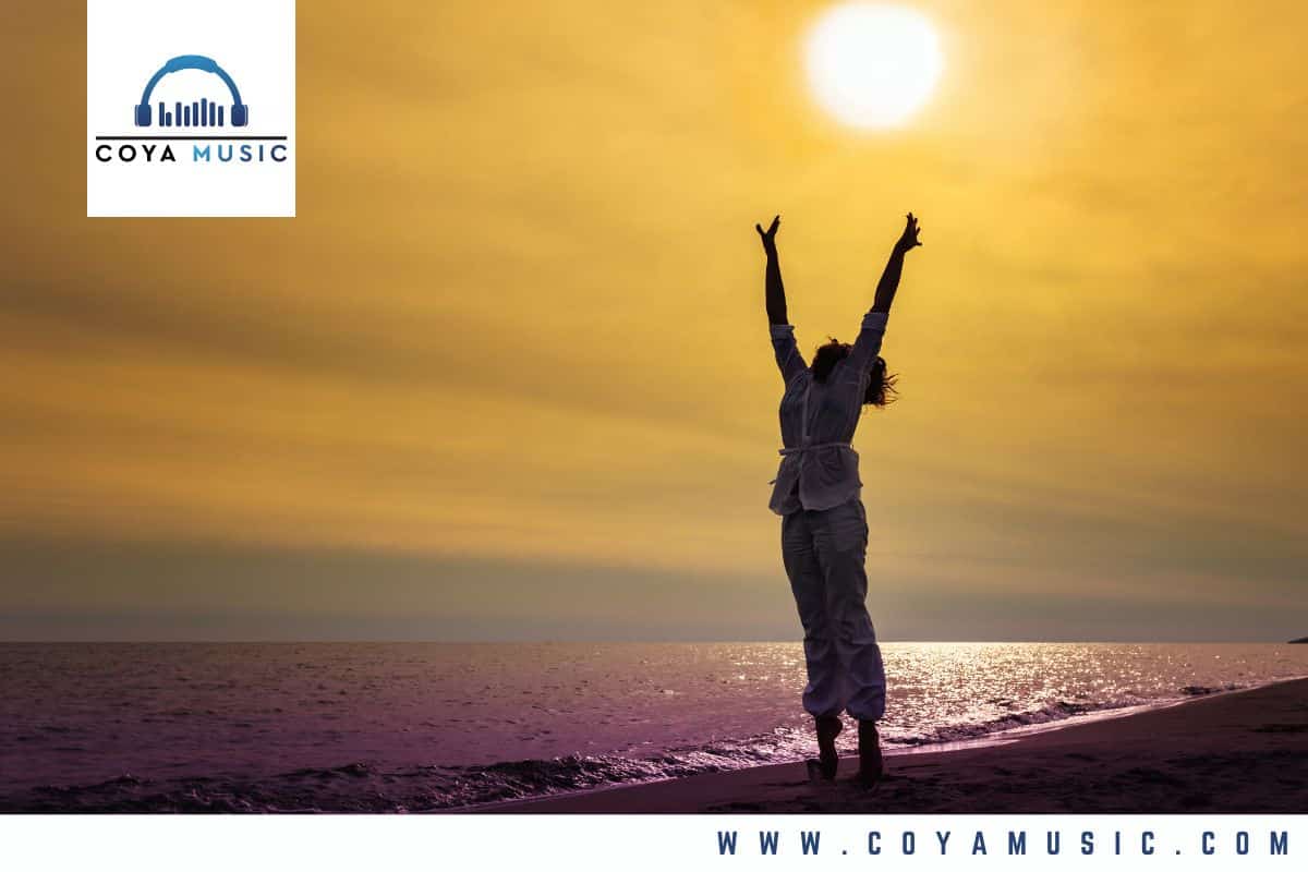 a woman lifts her hands to the sun